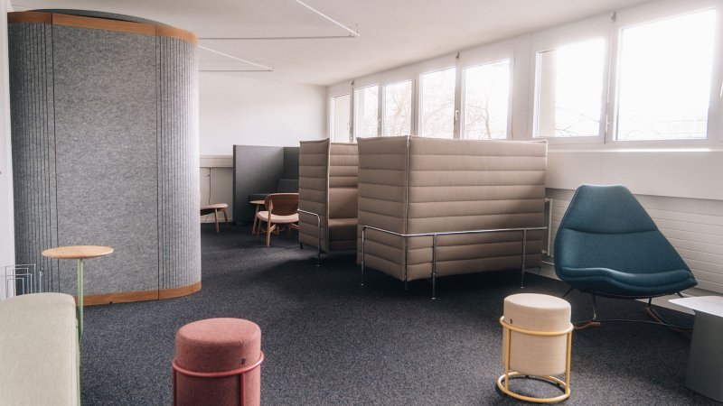 Lounge mit Telefonbox und verschieden Sitzmöbeln und Rückzugsbereichen